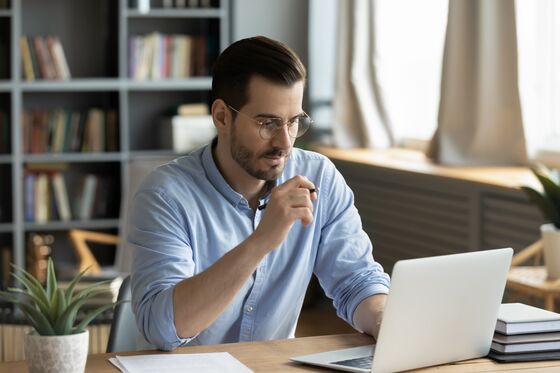 Junger Mann vergleicht am Computer, um bestes Girokonto zu finden