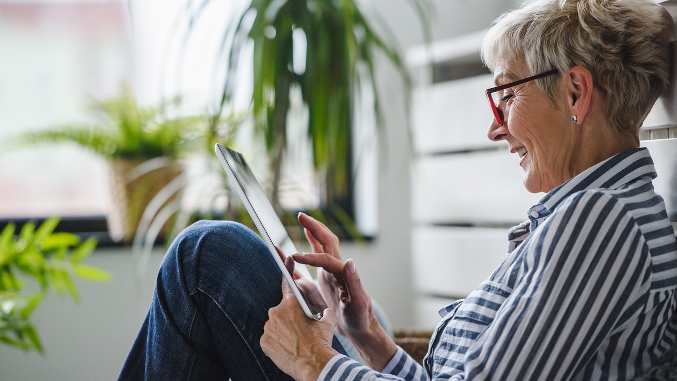 Frau nutzt Festgeld-Vergleich am Tablet